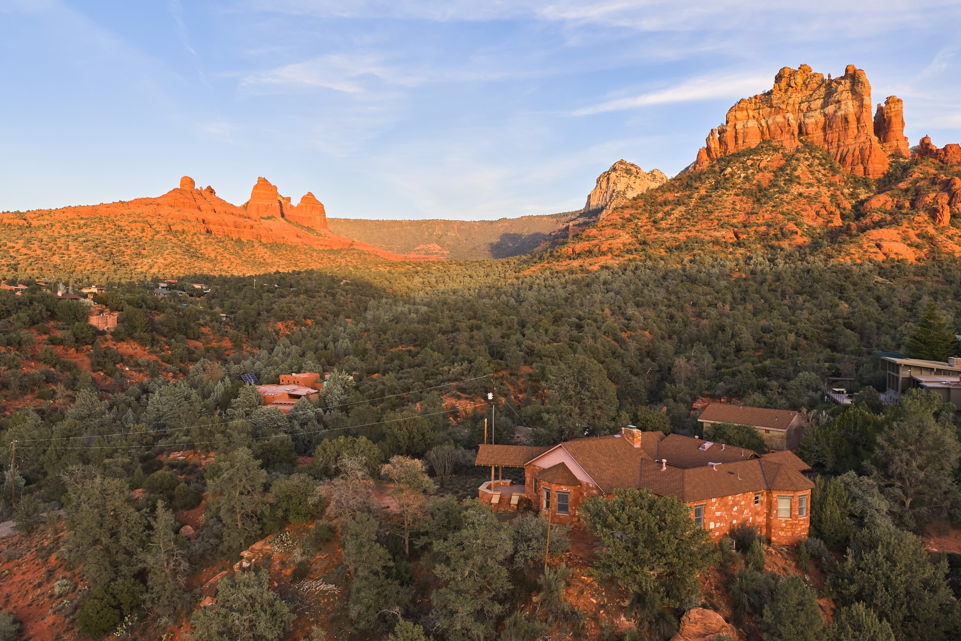 Aerial golden-hour view of estate with red rock formations on both sides